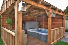 a hot tub sitting under a wooden roof