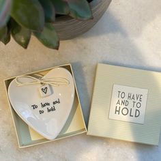 a white heart shaped dish in a gift box next to a card that says to have and to hold