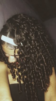 a close up of a person with long curly hair and glasses on her head,