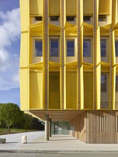 a yellow building with many windows and shutters