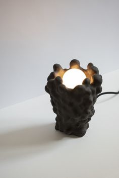 a lamp that is on top of a white surface with a light bulb in the middle