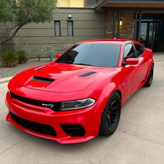 a red sports car parked in front of a building