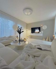 a living room filled with white furniture and lots of pillows on top of it's couches