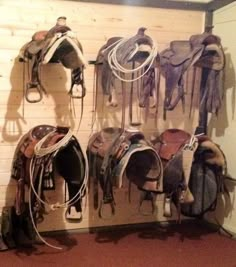 there are many different types of saddles hanging on the wall