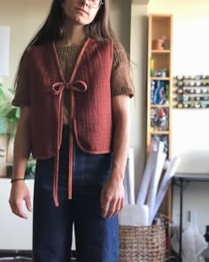 a woman standing in a living room with her hands on her hips