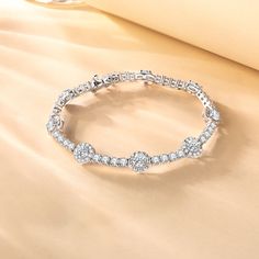 Our "Noble Allure" tennis bracelet is a masterpiece of elegance and sophistication, designed to captivate and enchant. The halo setting magnifies its beauty and brilliance. This bracelet is a mix of classic style and modern flair, perfect for anyone looking to add a touch of luxury to their look. Material: 925 Sterling Silver Length: 19cm Bracelet width: 8mm Gemstone width: 5mm Halo Setting, Bracelet Online, Sterling Silver Bracelet, Tennis Bracelet, Silver Bracelets, Sterling Silver Bracelets, Birthstone, Halo, Classic Style