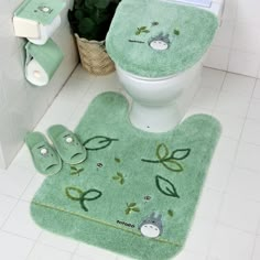 a bathroom with green rugs on the floor next to a toilet and towel dispenser