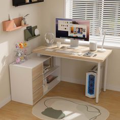 a computer desk with a monitor and keyboard on it next to a window in a room