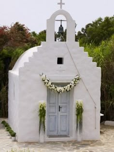 a white church with a blue door and cross