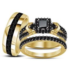 two gold wedding rings with black diamonds on each one and an engagement ring in the middle