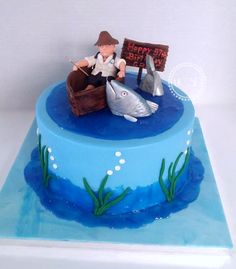 a birthday cake with a fisherman and dolphin on it's side, in the shape of a boat