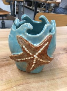 a ceramic starfish vase sitting on top of a wooden table