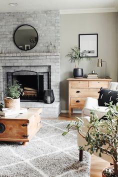 a living room filled with furniture and a fire place in front of a brick wall