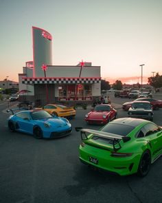 several cars are parked in front of a fast food restaurant at sunset or sunrise time