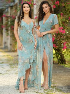 two beautiful women standing next to each other in front of some trees and pink flowers