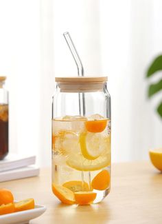 a mason jar filled with lemons and orange slices next to a glass of iced tea