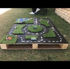 an outdoor play area made out of grass and toys on top of a wooden table