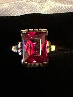 "For your consideration, a very vintage 10K red glass ring.  This beautiful piece is 10K and hallmarked and guaranteed to be such. Also, there is a maker's mark of \"RS\".  The red solitaire stone is emerald cut glass which was popular in the 30s and 40s.  The stone measures 10mm x 8mm and is set in a scroll setting on all four sides.  This fabulous ring is a size 5 3/4 and weighs in a at 4.28 grams. It is one fabulous vintage ring with lots of history yet to made!" Heirloom Red Ruby Ring For Formal Occasions, Red Heirloom Birthstone Ring For Formal Events, Vintage Rectangular Ruby Ring For Formal Occasions, Vintage Red Ring For Anniversary, Classic Red Ruby Ring With Vs Clarity, Red Emerald Cut Ring For Formal Occasions, Hallmarked Red Birthstone Ring For Anniversary, Classic Red Birthstone Ring, Formal Red Emerald-cut Ring