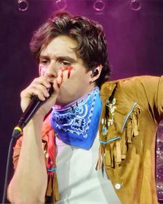 a man with blood all over his face holding a microphone