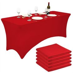 a red table cloth with place settings and wine glasses on the top, next to it