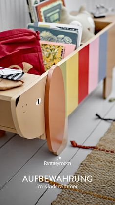 an animal shaped bench with books and other items in it's back compartment on the floor