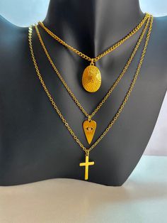 - Gold plated stainless steel 3 layer chain necklace with cross ,heart, oval medallion charms - Cross, heart charms are gold plated stainless steel, oval medallion charm is 24K gold plated - The length of necklace is 55 cm (21.7 inches), extend 5 cm (2 inches) - Colors may appear slightly different on screen due to differences in resolution, brightness, and contrast JEWELRY CARE - Keep jewelry dry - Take it off before taking shower, bath, swimming or exercising - Makeup, perfume, hairspray apply Trendy Handmade Gold Plated Jewelry, Handmade Gold Stainless Steel Jewelry, Handmade Gold Jewelry In Stainless Steel, Handmade Stainless Steel Gold Jewelry, Trendy Gold Cross Jewelry, Stainless Steel Jewelry With Delicate Chain And Round Pendant, Trendy Dangle Stainless Steel Jewelry, Metal Cross Jewelry With Adjustable Chain, Trendy Stainless Steel Dangle Jewelry