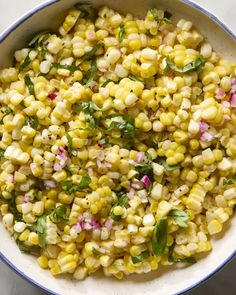 a white bowl filled with corn and garnish