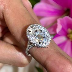 a close up of a person's hand holding a diamond ring