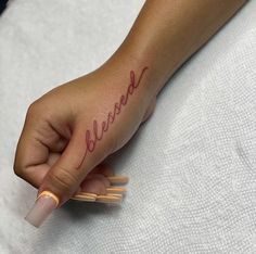 a woman's hand with a small tattoo that reads, be kindred on it