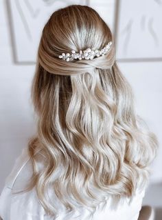 a woman with long blonde hair wearing a white dress and a flower headpiece in her hair