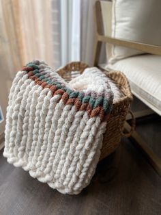 a crocheted basket sitting on top of a wooden table next to a couch