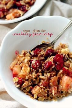 a bowl filled with granola and fruit on top of a white tablecloth covered table