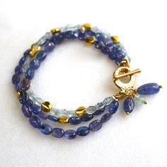 Glittering, vibrantly hued genuine polished natural periwinkle hued tanzanite, one of the rarest and most prized of all gemstones, sparkles on this strand in a beautiful bright striking splash of color! A linked strand of silvery blue baroque pearls pick up the colors of the tanzanite. A 14k gold lobster clasp secures this one of a kind piece at 7 - 8.5 inches long, however further adjustments can be made, please inquire. Blue Tanzanite Gemstone Bracelets, Luxury Blue Bracelets With Gemstone Accents, Luxury Blue Bracelet With Natural Stones, Luxury Blue Bracelets With Natural Stones, Blue Amethyst Beaded Bracelets As Gift, Blue Amethyst Beaded Bracelets For Gift, Blue Tanzanite Gemstones As Gifts, Blue Bracelet With Gemstone Accents As Gift, Blue Bracelets With Gemstone Accents As A Gift