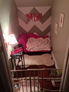 a small bedroom with a bed and stairs leading up to the top floor, which has a chevron pattern on the wall