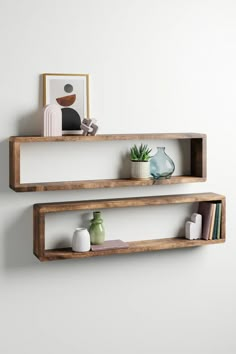 two wooden shelves on the wall with vases and bookshelves in front of them