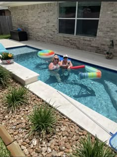 two people are in an inflatable pool with floats and water toys on it