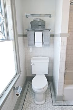 a white toilet sitting in a bathroom next to a window