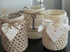 three crocheted jars with bows and tags on them sitting on top of a table