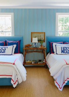 two beds in a room with blue and white striped walls