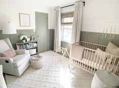 a baby's room with a crib, chair and bookcase in it