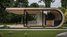 a modern house with an outdoor kitchen and dining area in the middle of a garden