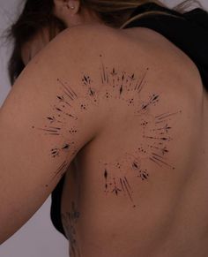 the back of a woman's body with black ink sprinkles on it