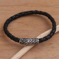 A rounded box clasp in combination sterling silver steals the show in this braided bracelet from Bali's Henry Anthony Sanny. Hand crafted in rich black leather the bracelet is accented by a sterling silver clasp engraved with rough textured pattern.