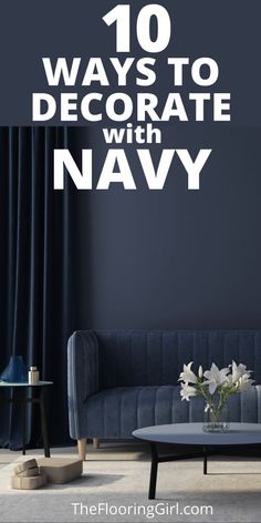 a living room with navy blue walls and white flowers on the coffee table in front of it