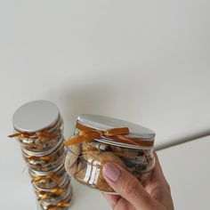 a hand holding a jar filled with cookies