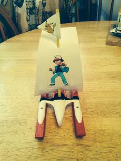 a wooden table with a toy boat on it and an image of a man in the middle