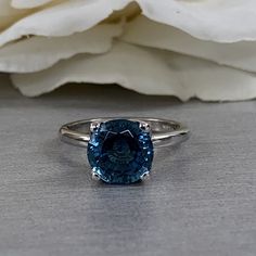 Solitaire Engagement Ring, Blue Stone Ladies Ring, Teal Blue Solitaire Ring, 14K White Gold #6893 #SolitaireRing #TravelRing #EngagementRing #LadiesRing #BlueStoneRing #BlueSpinel #GiftForHer #RoundSolitaire #BirthdayGift #AnniversaryGift Blue Solitaire Birthstone Ring With Round Band, Blue Sapphire Solitaire Ring For Formal Occasions, Blue Solitaire Birthstone Ring With Round Stone, Blue Solitaire Birthstone Ring, Classic Sapphire Solitaire Topaz Ring, Blue Solitaire Topaz Ring Round Cut, Blue Topaz Solitaire Ring Round Cut, Formal Blue Sapphire Solitaire Ring, Fine Jewelry Solitaire Topaz Ring With Round Cut