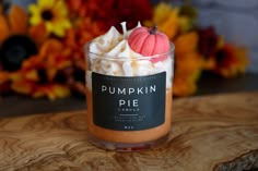 a pumpkin pie candle sitting on top of a wooden table