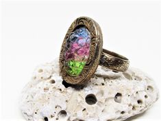 "A cool vintage 1960's / 1970's hippie era rainbow crystal ring. The ring is gold plated metal with an adjustable floral band and ornate spiral etched mount. The centerpiece of the design is a super unique oval shaped, rainbow striped, German sugar crystal in lime green, baby pink and sky blue. The crystal reminds me of a bed of raw crystals in nature, with bumpy gleaming facets. A super rare, fun ring, sure to make a statement! Gift boxed and ready for gift giving. -Age: Late 1960's / early 197 Vintage Multicolor Rings For Jewelry Making, Vintage Multicolor Rings For Gifting, Vintage Multicolor Rings For Gifts, Vintage Multicolor Rings For Gift, Vintage Multicolor Rings As Gift, Vintage Multicolor Oval Jewelry, Retro Rainbow Jewelry For Gifts, Multicolor Retro Rings For Gifts, Rainbow Retro Jewelry For Gift