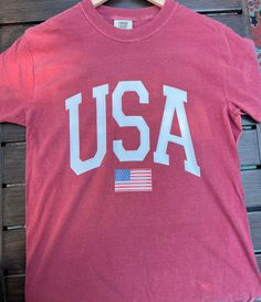 Comfort Colors Flag T- shirt ------DETAILS------ Design made with high quality vinyl, not printed. Design is heat pressed onto garment using vinyl Can be machine washed and dried For longer durability, turn inside out, wash cold and lay out to dry ------ SHIRT ------ 100% ring spun USA cotton Preshrunk, soft-washed, garment-dyed fabric Made with sustainably and fairly grown USA cotton and sewn with USA cotton thread Double-needle stitched sleeves and bottom hem vintage feel relaxed, less fitted Logo Shirt, Flag Shirt, Flag Tshirt, Dyed Fabric, Usa Flag, Cotton Thread, Printed Design, Fourth Of July, Comfort Colors